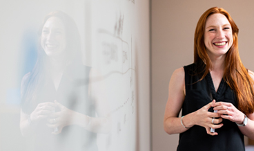 Teacher smiling and standing at whiteboard