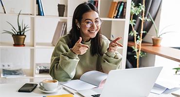 Girl smiling and pointing at laptop