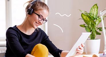 Student at desk with tablet and textbook