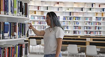 Student browsing bookshelves