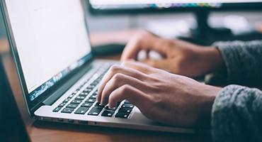 Close up of hands typing at laptop